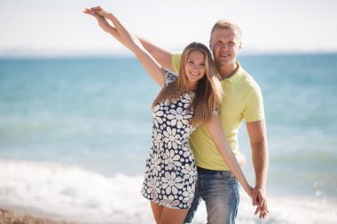 Denize sıfır plaj üzerinde sevgi dolu genç Çift