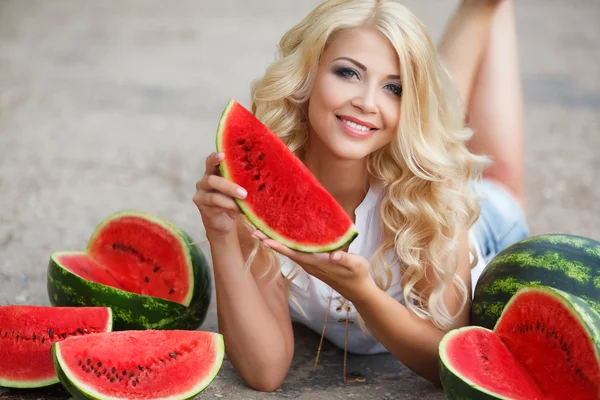 Beautiful young woman holding a slice of ripe watermelon — Stock Photo, Image