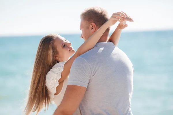 Unga älskande par på stranden nära havet — Stockfoto