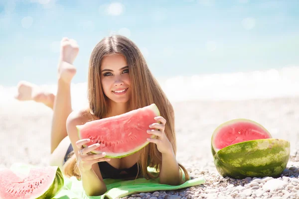 Hermosa chica en la playa comiendo sandía —  Fotos de Stock