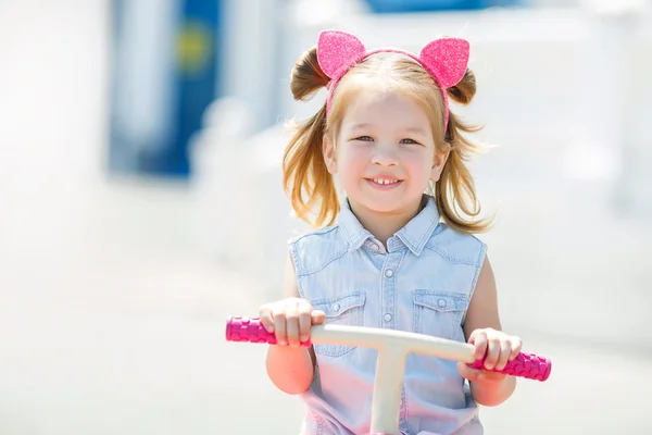 Little girl riding a bike in a city. — Stock Photo, Image