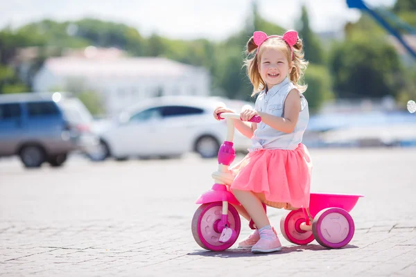 Petite fille en vélo dans une ville . — Photo