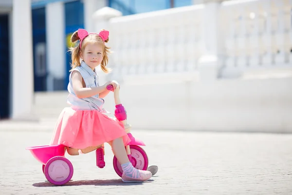 Malá holčička, jízda na kole ve městě. — Stock fotografie