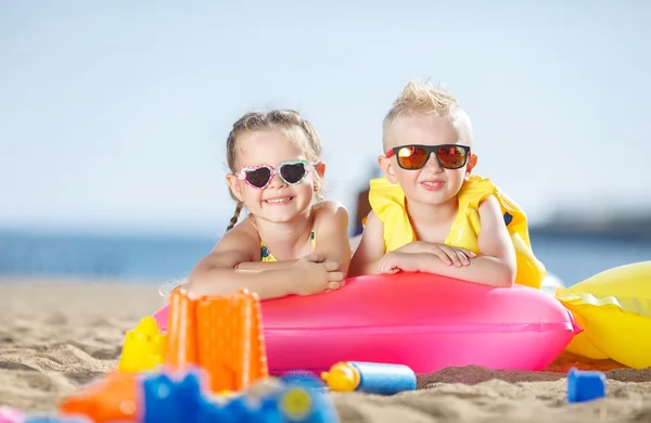 Gorgeous brother and sister sunbathing on a sandy beach — Stock Photo, Image