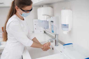 Güzel doktor ellerini sabunla yıkıyor.