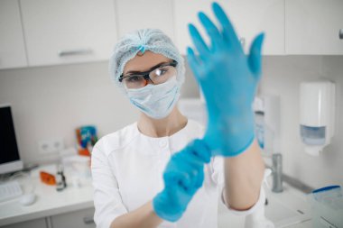 Maskeli ve eldivenli güzel bir kadın doktor portresi.