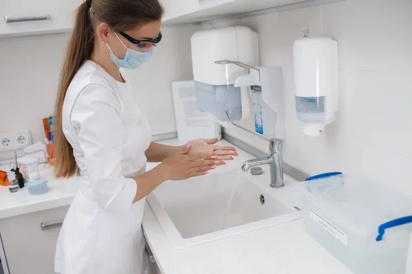 Mooie arts wassen haar handen met zeep — Stockfoto