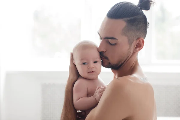 Homme avec nourrisson. famille heureuse à la maison. heureux père avec mignon deux mois bébé garçon couché dans un lit léger à la maison — Photo