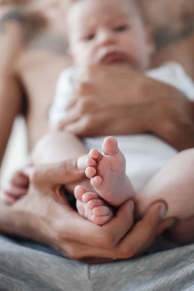 Uomo con neonato. famiglia felice a casa. felice padre con carino due mesi bambino sdraiato nel letto leggero a casa — Foto Stock