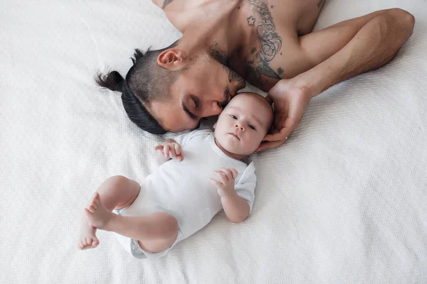 Homme avec nourrisson. famille heureuse à la maison. heureux père avec mignon deux mois bébé garçon couché dans un lit léger à la maison — Photo