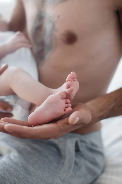 Homem com criança. família feliz em casa. pai feliz com bonito dois meses bebê menino deitado na cama leve em casa — Fotografia de Stock