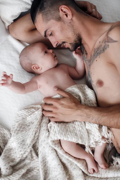 Homme avec nourrisson. famille heureuse à la maison. heureux père avec mignon deux mois bébé garçon couché dans un lit léger à la maison — Photo