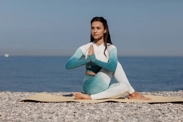 Biała młoda kobieta praktykująca jogę na wybrzeżu — Zdjęcie stockowe