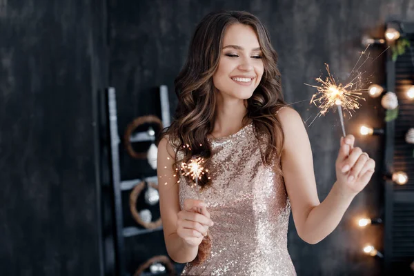 Fashion young beautiful woman in luxury dress. christmas and new year. girl with sparlight lights — Stock Photo, Image