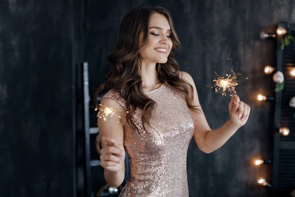 Fashion young beautiful woman in luxury dress. christmas and new year. girl with sparlight lights — Stock Photo, Image