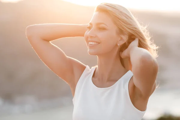 Retrato de uma jovem mulher feliz ao ar livre no pôr do sol ensolarado — Fotografia de Stock