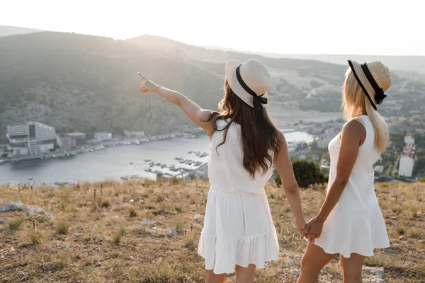 Dos amigos felices, concepto de turismo Vacaciones de verano. Los mejores amigos en vestido y sombrero. Mostrando el camino a mano — Foto de Stock