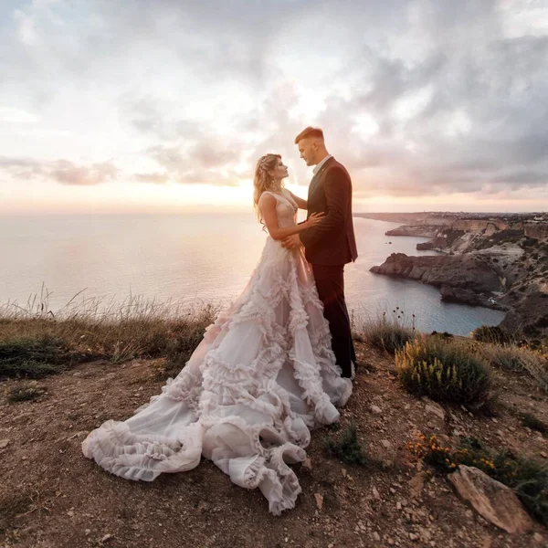 Porträt einer glücklichen Braut in Luxuskleid und Bräutigam, Hochzeit bei Sonnenuntergang — Stockfoto