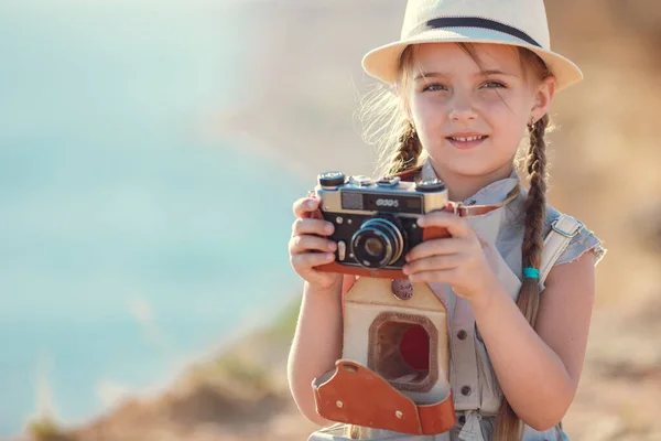 Gyermek lány utazó. egyedül utazom. lány séta kamera és bőrönd a természetben a tengeren. utazás, nyaralás, nyaralás — Stock Fotó