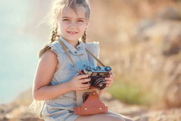 Criança menina viajante. viagem sozinho. menina andando com câmera e mala na natureza por mar. viagens, férias, feriados — Fotografia de Stock