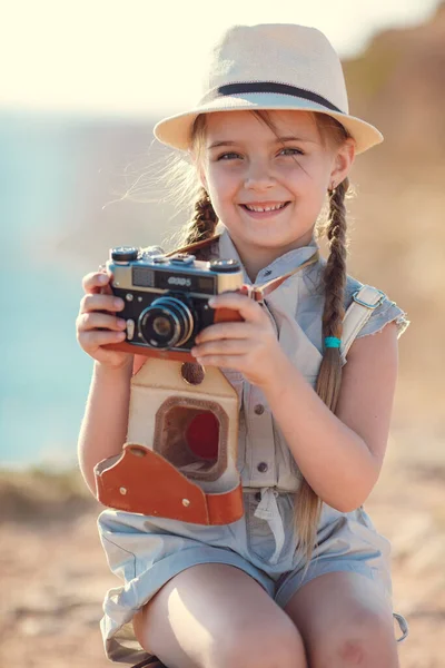 女旅行家。一个人旅行带着相机和手提箱在大自然中走海路的女孩。旅行、度假、假期 — 图库照片