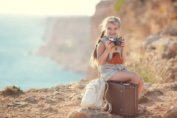 Enfant fille voyageur. voyage seul. fille marche avec caméra et valise sur la nature par la mer. voyage, vacances, vacances — Photo