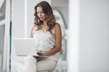 Dışarıda dizüstü bilgisayarı olan genç bir kadının portresi.