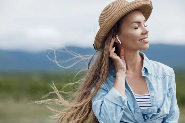 Joven hermosa mujer con auriculares inalámbricos al aire libre —  Fotos de Stock