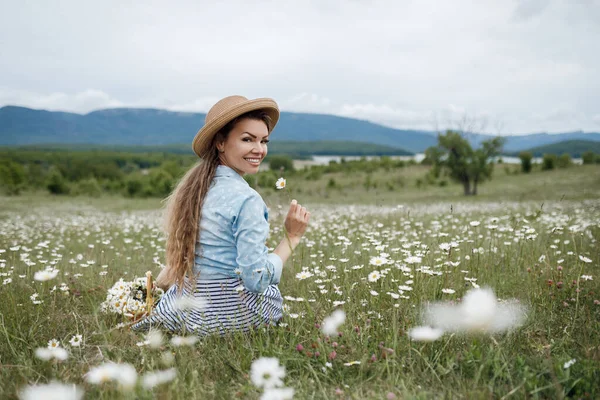 Närbild porträtt av en ung vacker kvinna i en kamomill fält — Stockfoto