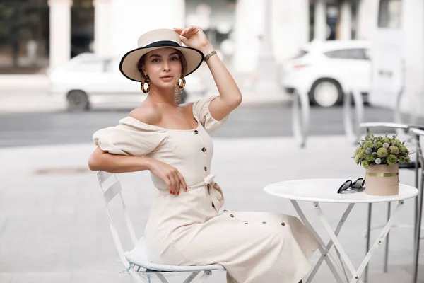 Moda jovem mulher no café com café, chapéu e óculos de sol — Fotografia de Stock