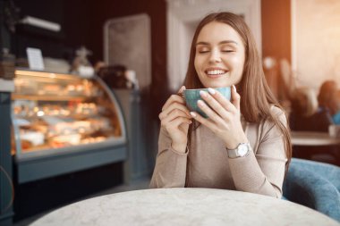 Kafede kahve ve kekle mutlu güzel bir kadın.