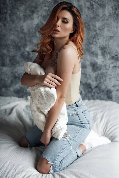 İç mekanda yatağın yanında güzel bir kadın. ciddi model — Stok fotoğraf