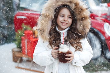 Güzel, genç bir kız. Uzun saçlı. Kar yağarken kakaolu çamur tutuyor. Kışın çocuk dışarıda.