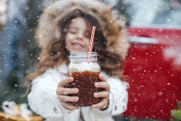 Muito menina pré-adolescente com cabelo longo beutiful segurando lama com cacau ao ar livre em tempo de neve. criança no inverno fora. — Fotografia de Stock