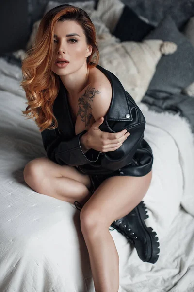 Mujer bastante sexy posando en estudio en chaqueta de cuero negro y botas —  Fotos de Stock
