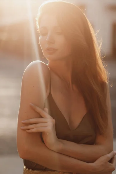 Vacker ung modekvinna i elegant klänning i city street i solnedgången ljus — Stockfoto