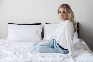 Yatakta mutlu bir genç kadının portresi.