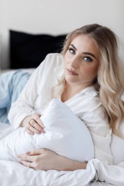 Yatakta mutlu bir genç kadının portresi.