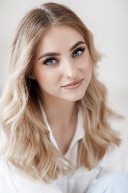 Mavi gözlü, güzel, sarışın bir kadının yakından çekilmiş portresi.
