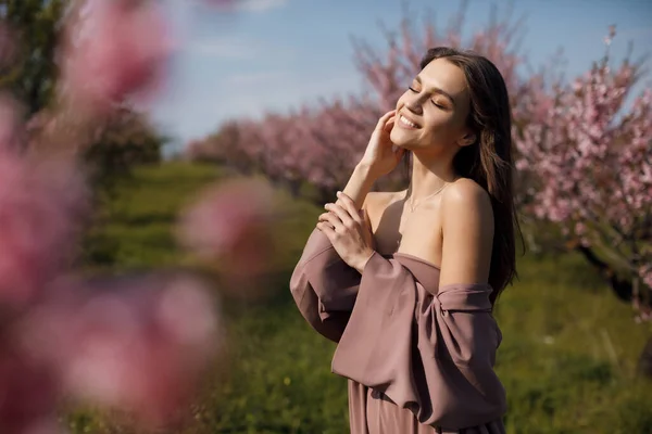 Krásná mladá žena venku v kvetoucím poli — Stock fotografie