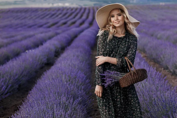 Retrato de moda de uma jovem mulher bonita no campo de lavanda em chapéu com saco — Fotografia de Stock