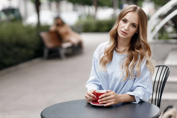 Jovem mulher calma com café no café ao ar livre na cidade — Fotografia de Stock