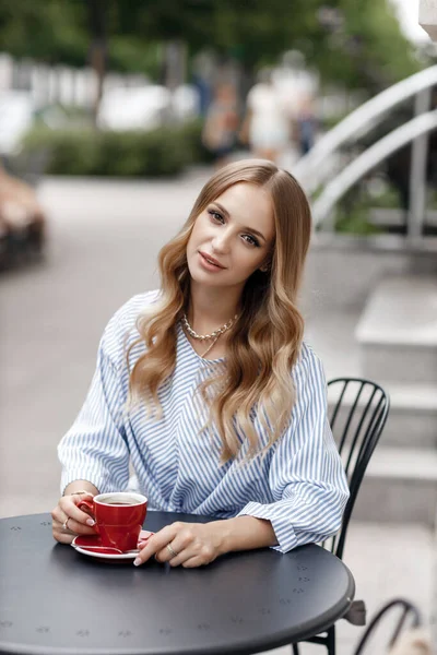 都会のカフェの屋外でコーヒーと若い穏やかな女性 — ストック写真