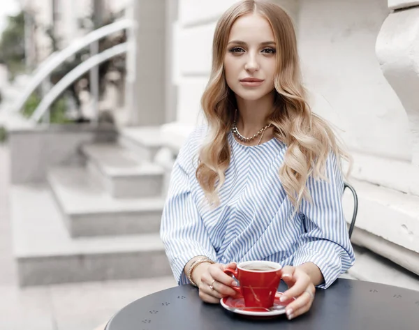 Junge ruhige Frau mit Kaffee im Café draußen in der Stadt — Stockfoto