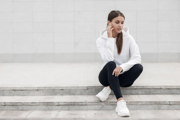 Mujer joven sentada después de la aptitud al aire libre con auriculares —  Fotos de Stock