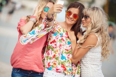 şehirde bir bankta oturan üç güzel genç kadın,