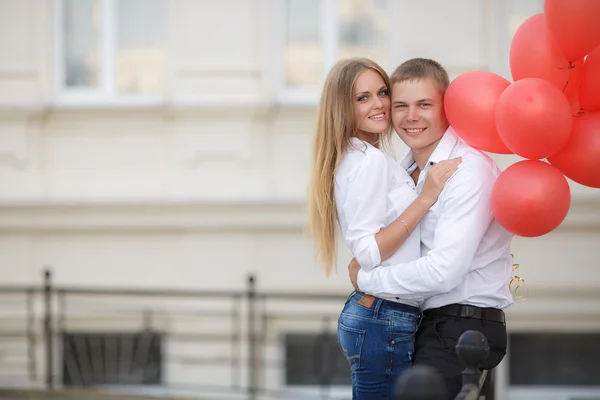 Young couple with colourful balloons in town. — Stock Photo, Image