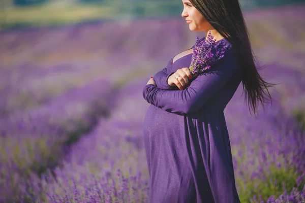 Een zwangere vrouw is genieten van de kleur lavendel — Stockfoto