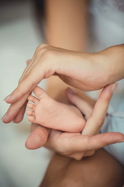 Newborn baby feet in mother hands. — Stock Photo, Image