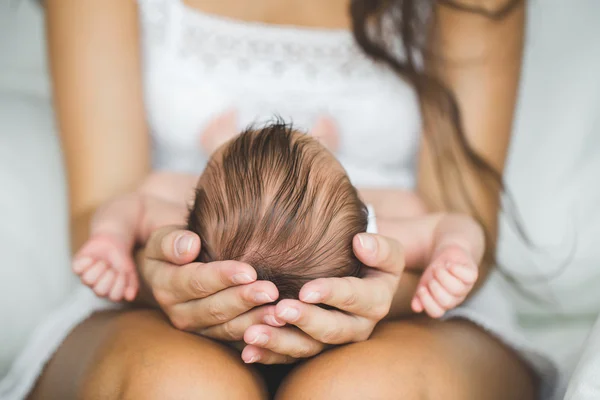 Die Mutter hält den Kopf ihres neugeborenen Sohnes — Stockfoto